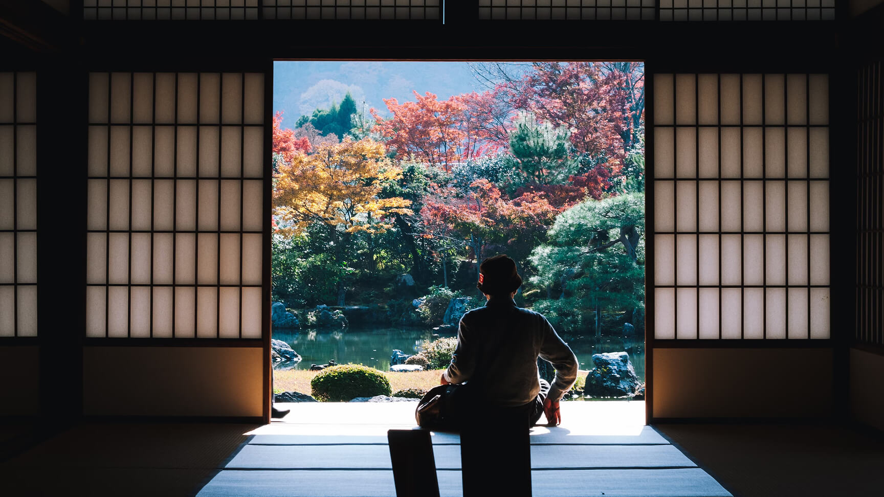 Persona sentada en la puerta de un cuarto de Japón. Hoteles con experiencias únicas en Japón